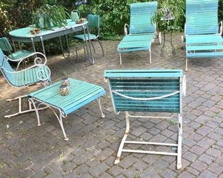 Vintage Mid-Century Woodard by Salterini Patio Set.
2 Chaise Lounges on Signature Wheels; 2 Bounce Chairs;  One Side Table. Replacement vinyl strapping and clips readily available. 