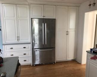 Kitchen cabinetry includes a large pantry. Nice stainless steel refrigerator. 