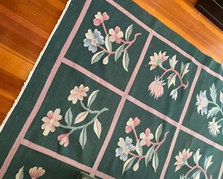 Green rug, cut down one edge.