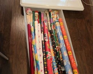 20 gallon storage tote with several rolls of gift wrap