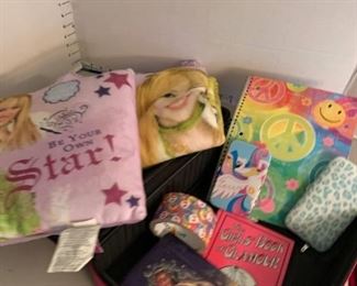 Girls suitcase filled with various items including Hannah Montana throw and pillow, journals, books and phone cases