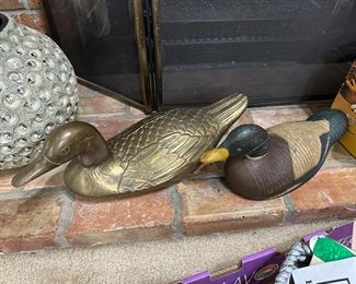 very large brass duck plus an older carved duck decoy