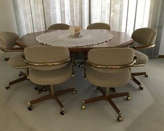 Very nice table with leaf and 6 upholstered chairs on castors 