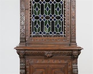         59	Victorian Renaissance Revival Carved Cabinet	"Victorian Renaissance Revival carved cabinet in the style of Herter Brothers. 19th century. Oak with carvings of cherubs and lion's heads, carved drawer and door, leaded stained glass door. One wooden shelf in bottom section, two glass shelves on top. Fitted with later illumination. Key is included. Scuffs and scratches to glass on door. Splits and wear to wood on carved molding on top left side of cabinet.  Losses to wood on top right molding on top of cabinet. Split and separation to molding on bottom center of cabinet. Leaded glass door is difficult to open and close and sticks against wood. Three loose pieces of molding and glue block are separated but present. White paint drips to back of cabinet. Illumination has been tested and works, with light shining dimly. 

37 3/4"" W x 22 1/8"" D x 88 1/8"" H. 158 lbs."
