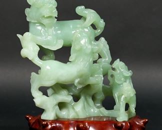         83	Carved Jade Foo Dogs Figurine	Carved jade Foo dogs figurine on rosewood stand, 7" H x 5 1/2" W. Chip to one side.
