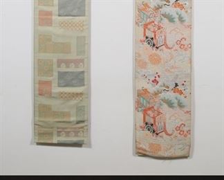         87	Japanese & Chinese Textiles Obi & Slippers	Lot of Japanese and Chinese textiles. 2 embroidered Japanese silk obi, one with flowers and geometric design, 171 1/2"L; one with cranes and flowers, 146"L, both on wooden hangers; pair of Chinese silk dragon slippers        87	Japanese & Chinese Textiles Obi & Slippers	Lot of Japanese and Chinese textiles. 2 embroidered Japanese silk obi, one with flowers and geometric design, 171 1/2"L; one with cranes and flowers, 146"L, both on wooden hangers; pair of Chinese silk dragon slippers. Geometric obi folded over and stapled on one end, light staining to both, wooden hanger chipped on one; light staining to slippers.
. Geometric obi folded over and stapled on one end, light staining to both, wooden hanger chipped on one; light staining to slippers.
