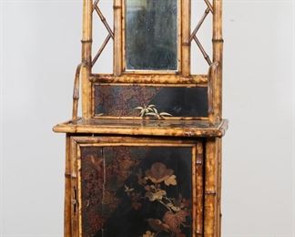        120	Aesthetic Movement Chinoiserie Bamboo Vanity	"Aesthetic Movement Chinoiserie bamboo vanity or washstand. Late 19th century. Bamboo frame, black and red lacquer, tooled leather sides and interior. Door opens to reveal storage with one shelf. Wear, scuffs, and scratches throughout bamboo of vanity. Wear and desilvering to mirror. Split to bamboo on left side of vanity.  Wear, scratches, chips and losses to lacquer on desk portion of vanity. Large cracks, splitting, and puncture to wood on door of vanity. Peg door pull is loose, as is door itself on top hinge. Wear and scuffs to leather. Crack to lacquer on top tier of vanity. Bent bamboo ""rungs"" on desk section of vanity are loose.

21"" W x 15 1/2"" D x 64 5/8"" H. 27 lbs."


