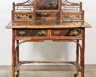        119	Aesthetic Movement Chinoiserie Bamboo Desk	"Aesthetic Movement Chinoiserie bamboo desk or dressing table. Late 19th century. Bamboo, lacquered top with inset leather portion, four drawers, and later casters. Wear, scratches, chips, losses, and stains throughout lacquer, leather and wood on top of desk. Nicks and scuffs to bamboo throughout desk. Wear to tooled leather on left and right sides of desk. Separations to bamboo molding on left side of desk. Losses to wood and bamboo on back right corner of desk. 

36 3/4"" W x 24 5/8"" D x 47 1/8"" H. 45 lbs.

"

