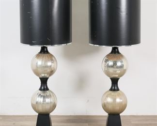        180	Pair of Mid-Century Modern Mercury Glass Lamps	Pair of mid-century modern mercury glass lamps. One shade with ili designed by P. Lobasso paper tag. Each lamp 52"H including harp and finial. Some discoloration to glass, minor scratches and losses to bases, scratches and losses to paper drum shades.

