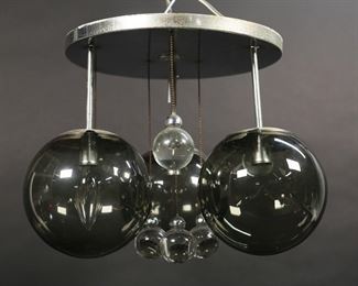        185	Lightolier Modern Chrome 3 Light Chandelier	Lightolier mid-century modern flush mount ceiling fixture. Chrome, with 3 smoked glass globes and 6 hanging glass ball drops. Lightolier paper label. 10 1/2" from cap to bottom of globes, cap 11"-diameter. Minor chips and flakes to rims of shades, minor losses and scratches to patina on chrome.

