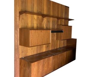        201	Poul Cadovius Danish Modern Royal System Wall Unit	"Poul Cadovius (Danish, 1911-2011). Royal System three-bay Danish Modern wall unit. Circa 1960s. Includes three wall panels for mounting cabinets, bookcase cabinet with two sliding doors, liquor cabinet with bottle rack and drop front door, cabinet with one shelf, two record cabinets with slide-out shelves, a metal light bracket, and four 31 1/2"" W and two 15 3/4"" W shelves with eight triangular brackets. Three replacements cabinet back panels and shelf wrapped in original paper, two peg hole cabinet back panels, wall panel joining splines, and shelf bracket hardware is included along with a Poul Cadovius flyer. ""MADE IN DENMARK"" impressed into back edge of one shelf. No apparent maker's marks or labels. All as is, with small scuffs, scratches and wear to tops and sides of cabinets. Mold, chips, water damage, and losses to wood on bottom of wall panels. Two splines are broken. Staining and losses to finish on interior of