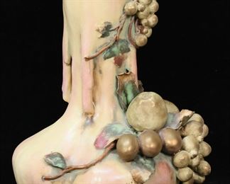        270	Amphora Edda Pottery Vase Grapes	Amphora Turn Teplitz Austrian pottery vase. Applied grapes, crabapples and leaves. Incised Amphora mark and Austria 8618 56, with raised Edda marks, on the underside. 11"H. Crazing throughout, section of vine chipped and missing, roughness and minor chips to leaves throughout, vine chipped from grapes at top, end of vine missing along base.
