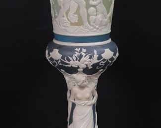        271	Mettlach Jasperware Pedestal Vase	Mettlach jasperware porcelain pokal / pedestal vase. Allegorical scenes in relief. Incised mark on the underside Mettlach 2418. 22"H x 6 1/2"-diameter at top. Some discoloration and scratches to interior.
