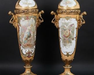        279	Pair of Sevres Style Porcelain Urns	Pair of Sevres style French porcelain urns. Gilt bronze mounts and figural gilt bronze handles, scenes with nymphs and Cupids, artist signed Collot. Blue Sevres-style interlaced double L marks with S... France below to the interior of each lid, France marked on rim of each lid. Each 19 1/4"H including lids. Minor losses to gilt decoration on rims, chips to rims of both lids, wear around finials on both lids, large chip at finial on one lid, wear and scratches from fitting at bottom end of urns.
