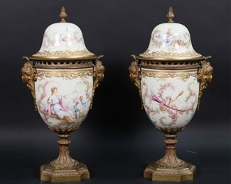        280	Pair Sevres Style Porcelain Urns	Pair of hand painted Sevres style porcelain urns with gilt bronze mounts. Scenes of women with cherubs and flowers, both artist signed R. Daurat. Blue interlaced double L with BB marks to interiors of both lids. Each 12"H. Minor losses to gilt painted decoration on rims of lids, crack to bronze on one.
