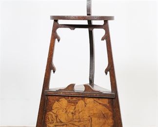        307	English Arts and Crafts Tiered Wine Side Table	"English Arts and Crafts tiered side table. Early 20th century. Back support in carved bird head finial, carved feet, door decorated with image of monks drinking beer and wine. Top tier of table is carved with motif of grapes and vines with inscription "" FILL UP THE BUMPER AIR, FOR EVERY DROP WE SPRINKLE, OER THE BROW OF CARE, SMOOTH'S AWAY A WRINKLE."" Chips and losses to wood on carved feet of table. Nicks, scuffs, and losses to wood on edges of posts supporting top tier. Scratches and marks to wood on scene of drinking friars. Hanging finial missing from right post on table. Repairs to back post of table where top of lower tier meets post. 

23 5/8"" W x 18"" D x 45 1/2"" H. 13 lbs."
