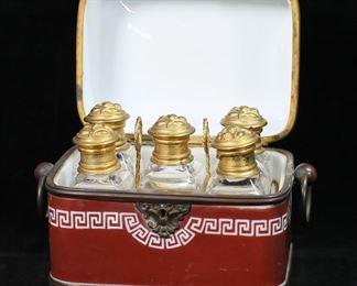        331	Hand Painted Opaline Glass Scent Casket	White opaline glass scent box. Hand painted figural lid and Greek key decoration, bronze mounts, gilt metal fitted interior. 5 crystal scent bottles with brass lids. Box 6"W x 4 3/8"D x 5 1/8"H, bottles each 3 3/4"H. Scratches and losses to painted decoration on box, losses to gilt decoration around rim, some losses to patina on mounts, scratches to underside of box, chips and roughness to interior rim of lid, scratch to interior of lid; bottles two stoppers frozen, chip to corners of two, one with chip to corner and side, one stopper chipped at top and frozen, chips and flakes to interior ends of stoppers on all.
