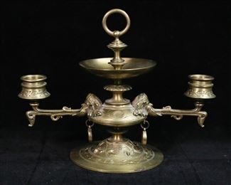        333	Tiffany Studios Gilt Bronze Double Arm Candlestick	Gilt bronze figural double arm candlestick. Greek masks holding arms, with coins and floral decoration. Stamped on the underside Tiffany Studios New York. 9 3/8"W x 7 1/4"H. Chip to one candle holder, oxidation and loss to patina on base.
