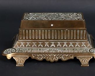        383	3 Brass Desk Items Including Calendar Ink Stand	3 brass desk items. Ink stand with perpetual calendar, circa early / mid-19th century; inkwell, foo dog. Ink stand 9"L x 3 1/4"H. Ink stand one hinge for lid missing pin, oxidation and losses to brass patina throughout, wear and losses to interior of lid, wear to fabric and printing for calendar, top calendar dial does not turn; deco inkwell some oxidation and losses to brass patina.
