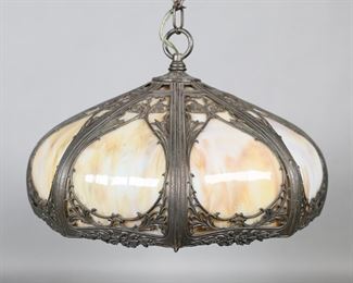        391	Slag Glass Hanging Fixture	Hanging light fixture, caramel slag glass with metal overlay. 10 1/4"H to top of ring, shade 15"W. Small sections of overlay missing throughout.
