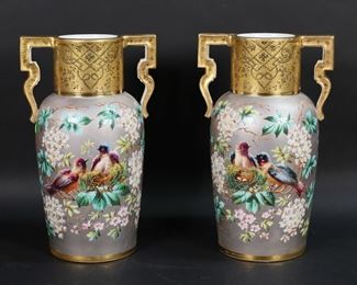        390	Pair of Hand Painted Porcelain Vases	Pair of two handled porcelain vases. Hand painted, gray ground with bird and flower motif, gilt decorated rims, handles and bases. Unsigned. Each 11 1/4"H. Losses to gilt decoration throughout both, scratches and losses to gray, repair and lines around base of one handle.
