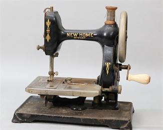        402	New Home Midget Sewing Machine	New Home "Midget" sewing machine. 10 1/4"L x 10 1/4"H. Rusting and paint loss throughout.
