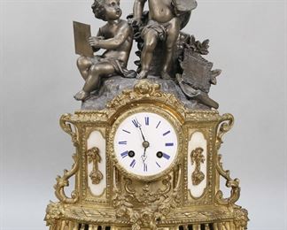        411	French Style Gilt Metal Cherub Clock	French style gilt metal clock with white metal artist cherub topper. Works, face and case all unmarked. 12"W x 17 1/2"H. No glass, missing rear door, arm of seated cherub repaired, clock does not appear to be working.
