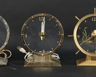        413	5 Haddon Mystery Clocks	5 Haddon mystery clocks. 2 Commodore ship's wheel clocks with nautical motif faces, 3 Golden Visionette clocks. Commodore 8 1/2"H. No glass on Visionette with black face, minute hand bent on one Visionette. All with losses and pitting to brass patina. One Visionette running, timekeeping untested.
