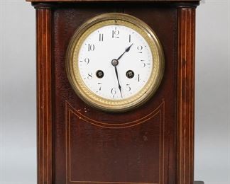        418	Harris & Harrington French Mantel Clock	French wooden mantel clock with columns. Dial marked France, works marked H&H (Harris & Harrington) with 1889 gold medal. 8 3/4"W x 6"D x 11 3/4"H. No pendulum, clock untested. Split to center of case above face, split to front of case along right side, crazing throughout case, chips and minor losses to wood throughout case, split to rear of case above door, scratches and losses to brass patina on door.
