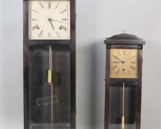        419	2 Gilbert Wall Clocks Hollywood & Belfair	2 American wall clocks. Gilbert, Winstead, Connecticut. Belfair model wall clock, 16 7/8"H; Hollywood model wall clock, 24 1/4"H. Both untested. Belfair with minor chips and scratches to case, scratches and discoloration to face, chips along top edge of case; Hollywood with minor chips and scratches to case, chips and losses to wood along edges of door and at lower corner, wear and losses to wood along bottom edge, scratches and losses to silvering on face.
     