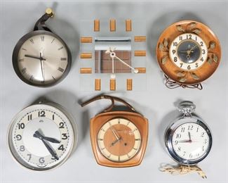        422	6 Modern Wall Clocks	6 mid-century modern wall clocks. United giant pocket watch, Dugena teak clock with rope hanger, United teak clock with gilt metal leaf decoration, ATO circular wall clock, Junghans ATO-MAT circular wall clock with leather hanger, glass and Lucite clock. Dugena 9"W x 8 3/4"H. United pocket watch clock face repaired and scratched, Dugena discoloration to face around keyholes and paint loss to back cover, United leaf clock paint loss to back cover, discoloration to dial and face, chips to wood around edge; ATO clock some discoloration to face and wear to metal around face, chips to paint around edge of Junghans; glass clock hands repainted. Both United clocks run, timekeeping untested; Dugena, Junghans, glass and ATO untested.
