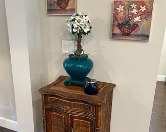 Faux wicker chest with drawer snd shelf. 
Teal vase floral arrangement and flower pictures on canvas