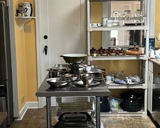 Stainless steel prep table. Nesco roaster. Various Scandinavian stainless steel serving pieces. Copco cast iron pan.