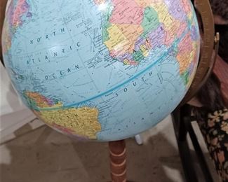 This globe is raised relief and sits on a stand