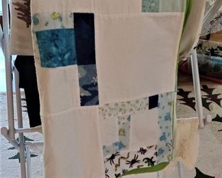 Linen rack with a baby quilt, doilies and more