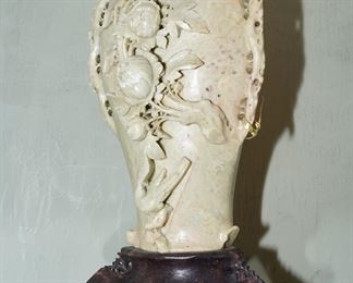 Carved soapstone vase on carved colored stone stand