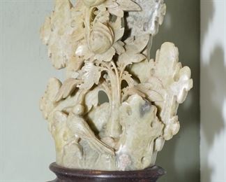 Carved soapstone figural floral on carved colored stone base.