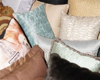 There are many pillows and linens in various shapes and sizes.