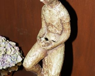 Cast iron sculpture of a little boy holding a bird