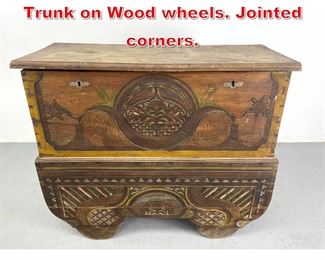Lot 552 Antique Continental Carved Trunk on Wood wheels. Jointed corners. 