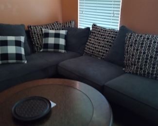 Grey corduroy sectional
Coffee table and end table
Also not pictured a large black leather rectangular cushioned bench