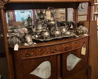 Oak buffet with stained glass and claw feet - Note the tea service, as well, and the many candle holders