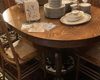 Oak pedestal claw foot table with seven chairs and two leaves