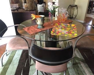 Glass top table with chairs and round area rug