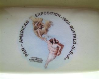 Lot 019   1901 Pan-American Exposition porcelain pin tray, gilt corners with the Pan-Am logo centered, 3 3/4" x 6" x 3/4".                   Cond:  No chips or wear.  Est.$40-60.