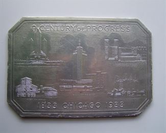 Lot 033    1933 "A Century of Progress, 1833 Chicago 1933" embossed aluminum foiled hot plate, 9 3/4" x 6 3/4".  Cond:  Very minor wear around the edges.  Est. $30-50.