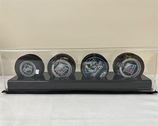 Collection of 4 NHL pucks - 2 signed by #28 - in display case
