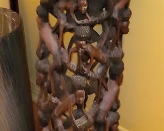 sculpture a carved figure playing percussion instrument with burlap clothes and encrustation.