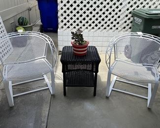 Vintage pair of wrought iron chairs along with black outdoor table