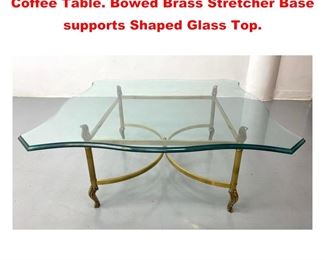 Lot 1111 Brass and Glass Regency style Coffee Table. Bowed Brass Stretcher Base supports Shaped Glass Top. 